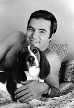 Burt Reynolds lying on the bed with his Basset Hound