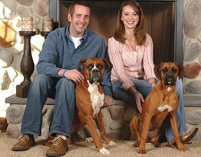 Greg Biffle and his wife with their two Boxer Dogs sitting on the floor