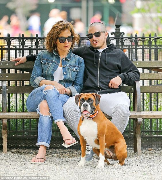 Jennifer Lopez with her boyfriend sitting on the bench at the park while keeping an eye at their Boxer Dog sitting on the ground