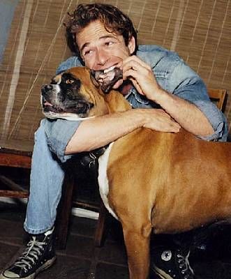 Luke Perry play biting the ears of his Boxer Dog