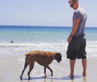 Sean Lowe by the seashore with his Boxer Dog