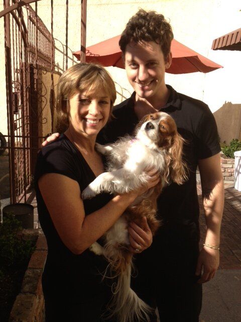 Dorothy Hamill carrying a Cavalier King Charles Spaniel dog together with a guy