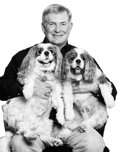 Mack Brown with two Cavalier King Charles Spaniels in his lap