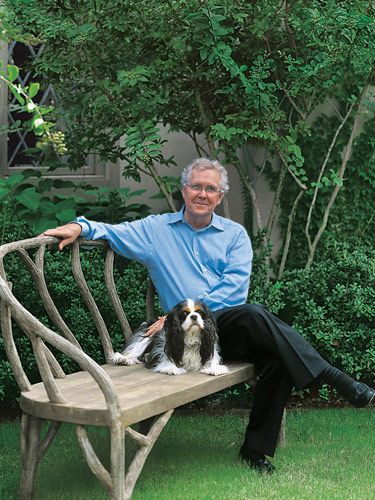 Charles Faudree in the garden sitting with his Cavalier King Charles Spaniel dog