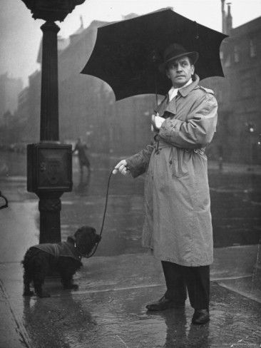 Fredric March in the street while raining with his Cocker Spaniel