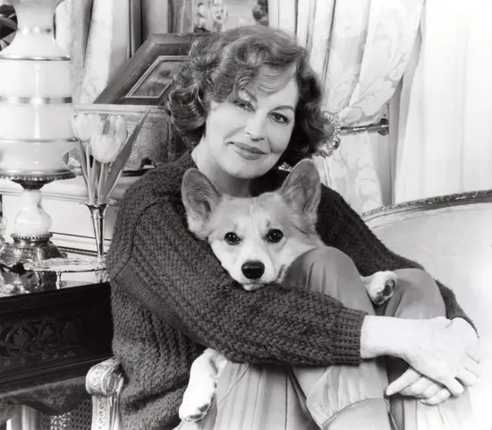 Ava Gardner sitting on the couch with her Corgi in her lap