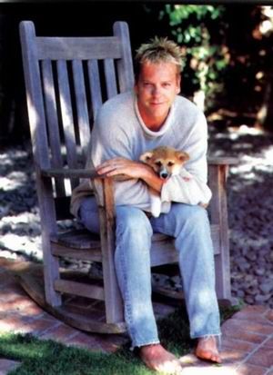 Kiefer Sutherland sitting on the chair in the backyard garden with his Corgi in his lap
