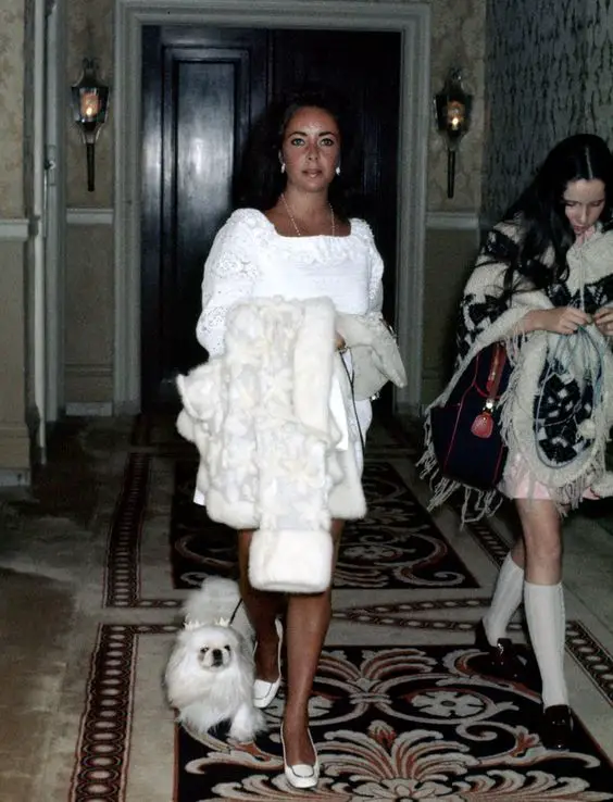 Elizabeth Taylor walking in the hallway with her Pekingese