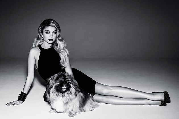 Sarah Hyland sitting on the floor behind her Pekingese