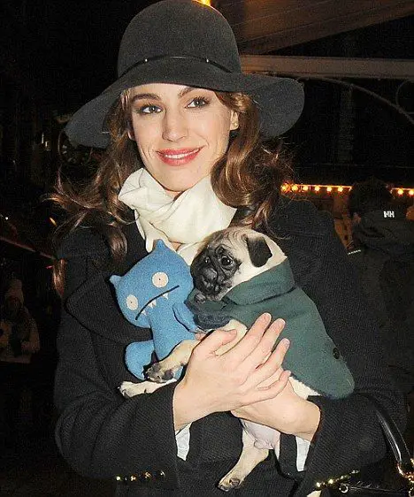 Kelly Brook carrying her Pug and its toy in her arms