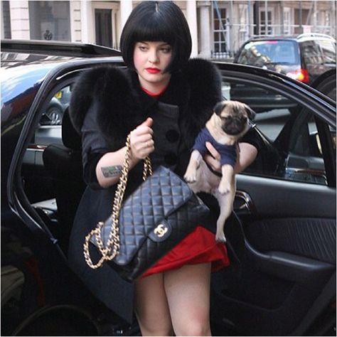 Kelly Osbourne getting out from her car while carrying her Pug