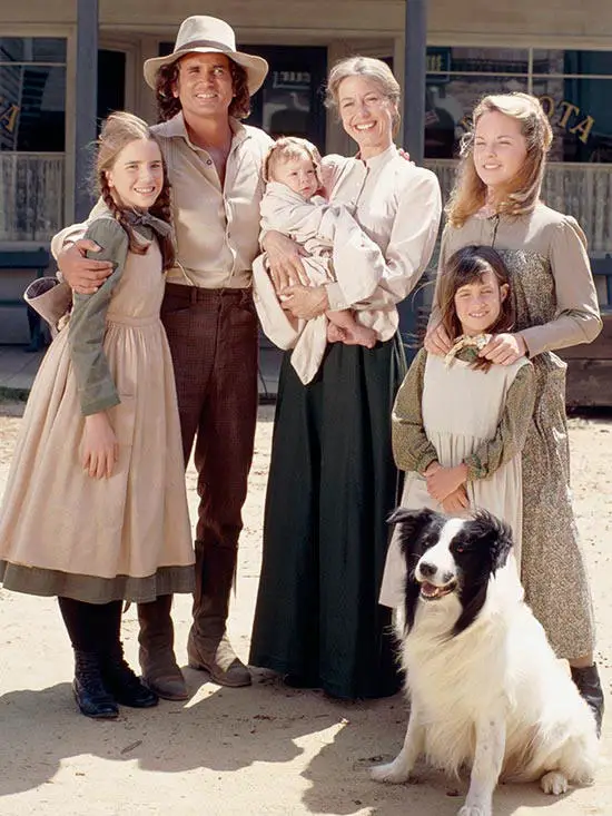 A family photo with a Border Collie sitting on the ground