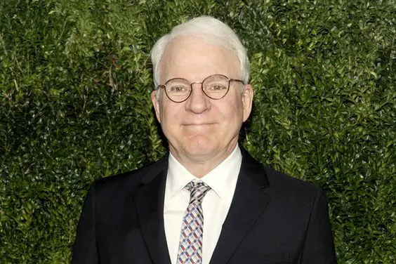 Steve Martin with a green wall background