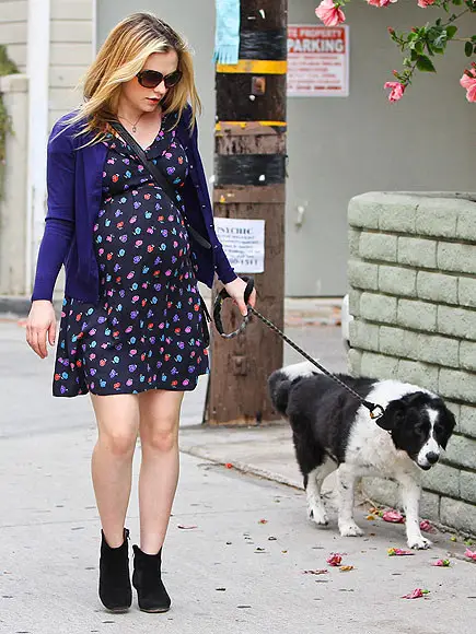 pregnant Anna Paquin walking in the street with her Border Collie on a leash