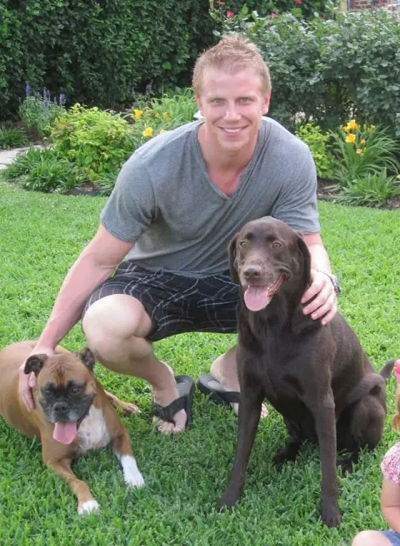 Sean Lowe in the backyard with his Boxer Dog and Labrador