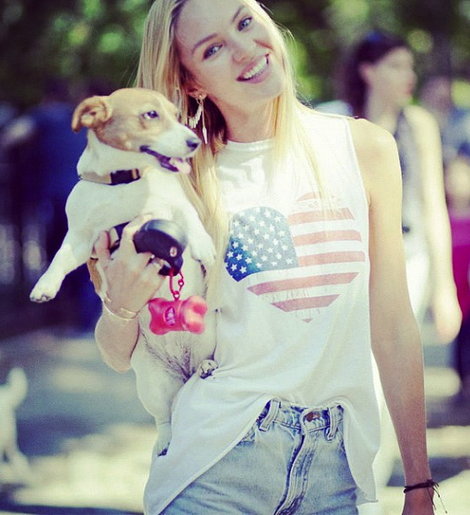 Candice Swanepoel walking in the street while holding her Jack Russell