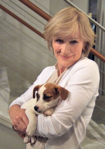 Glenn Close holding her Jack Russell puppy next to the stairs