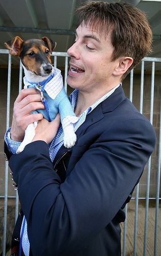 John Barrowman carrying his Jack Russell while talking to him