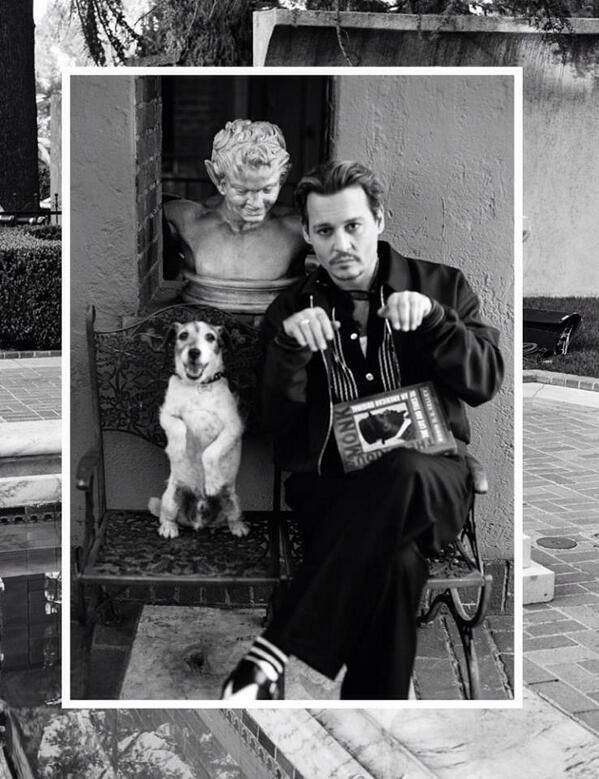 Johnny Depp sitting on the chair next to his Jack Russell doing a sitting pretty