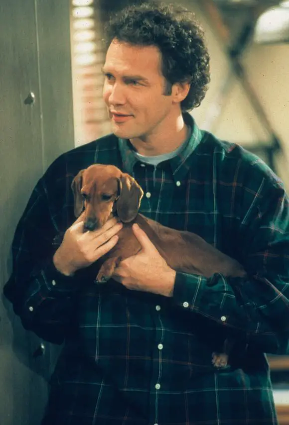 Norm Macdonald carrying his dachshund dog