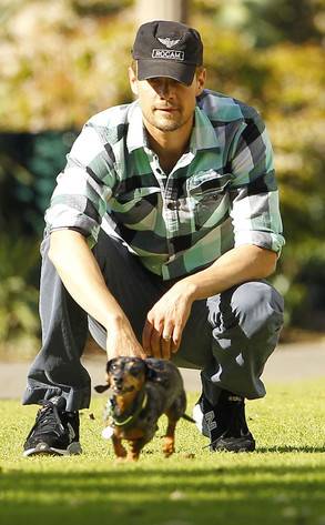 Josh Duhamel playing with his Dachshund at the park