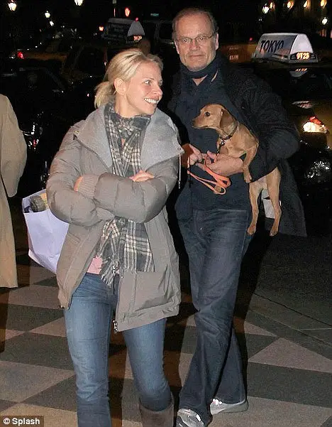 Kelsey Grammer with her husband carrying their Dachshund