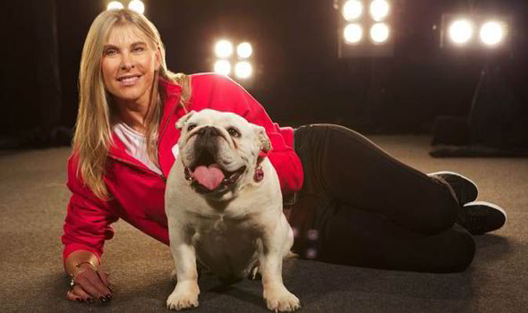 Sharron Davies on the floor behind her smiling English Bulldog