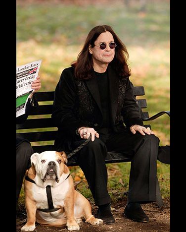 Ozzy Osbourne sitting on the bench with his English Bulldog