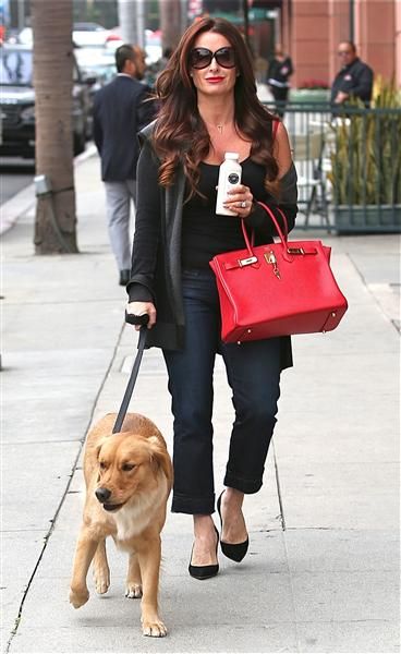 Kyle Richards walking in the street with her Golden Retriever