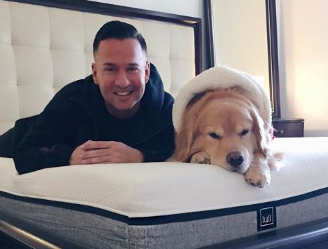 Mike Sorrentino lying down on the bed with his Golden Retriever