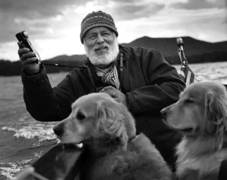 black and white photo of Bruce Weber in the boat with his two Golden Retrievers 