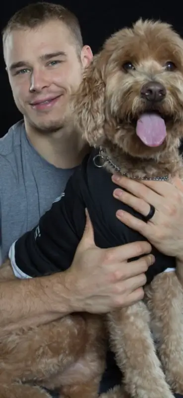 Dustin Brown with his Goldendoodle in his lap