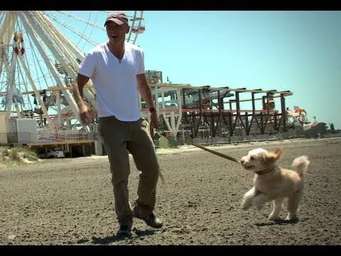 Kenny Chesney walking at the park with his Goldendoodle puppy