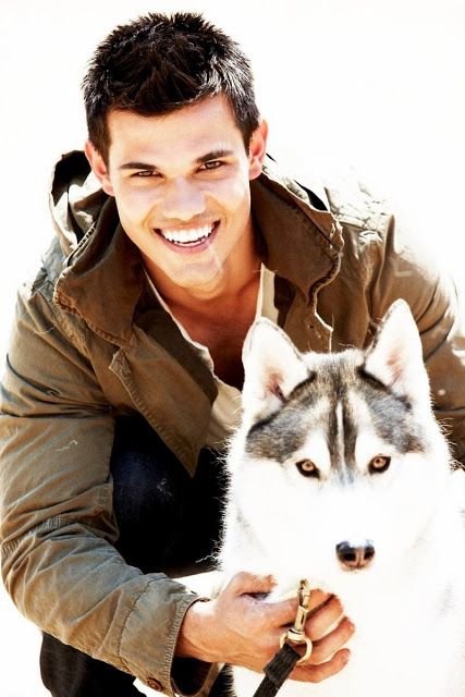 Taylor Lautner with his Husky sitting in front of him