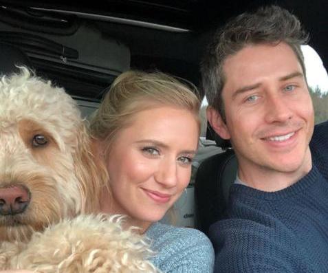Arie Luyendyk Jr. and Lauren Burnham taking a selfie inside the car with their Labradoodle