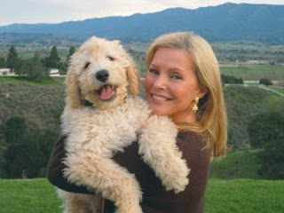 Cheryl Ladd carrying her smiling Labradoodle