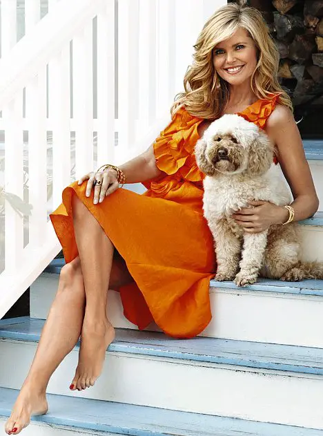 Christie Brinkley sitting on the stairway with her Labradoodle