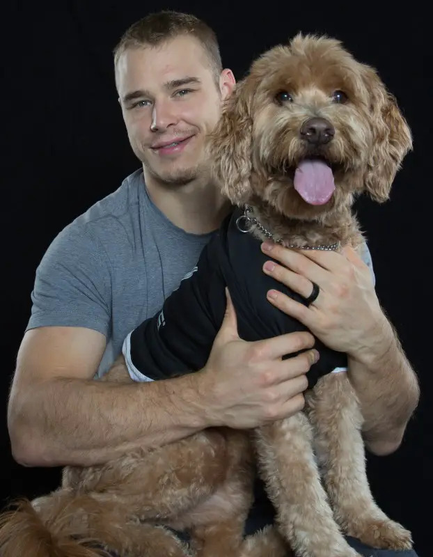 Dustin Brown with his Labradoodle in an isolated black background