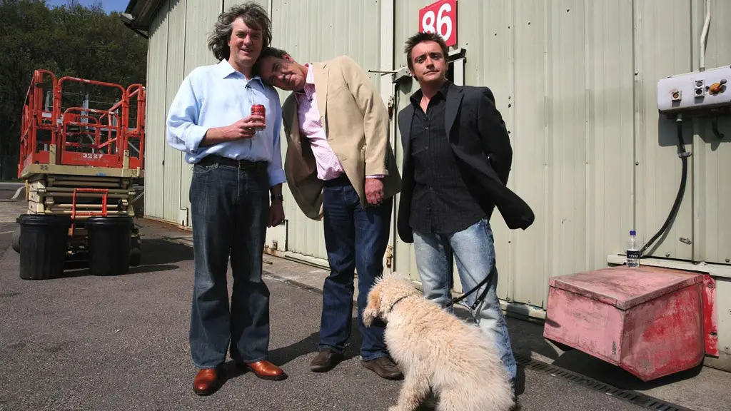 Jeremy Clarkson with two other celebrities and his Labradoodle sitting on the floor