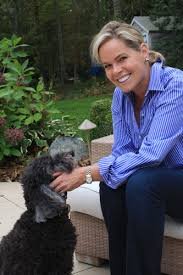 Pam Krueger sitting in the veranda petting her Labradoodle