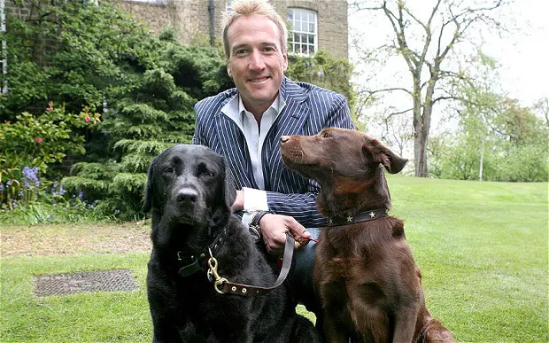 Ben Fogle in the yard with his black and chocolate labrador