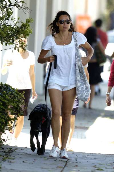 Minnie Driver walking in the street with her black labrador