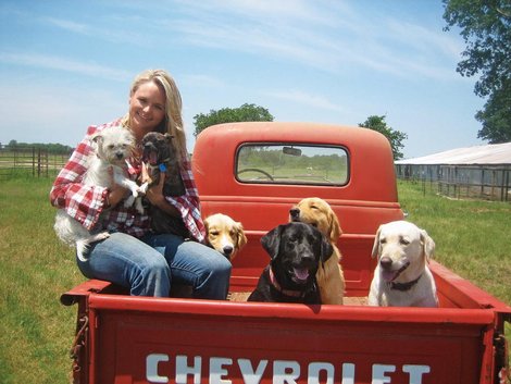 Miranda Lambert sitting on the side of the car trunk with her dogs