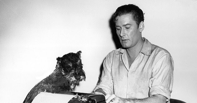 black and white photo of Errol Flynn working with his Schnauzer