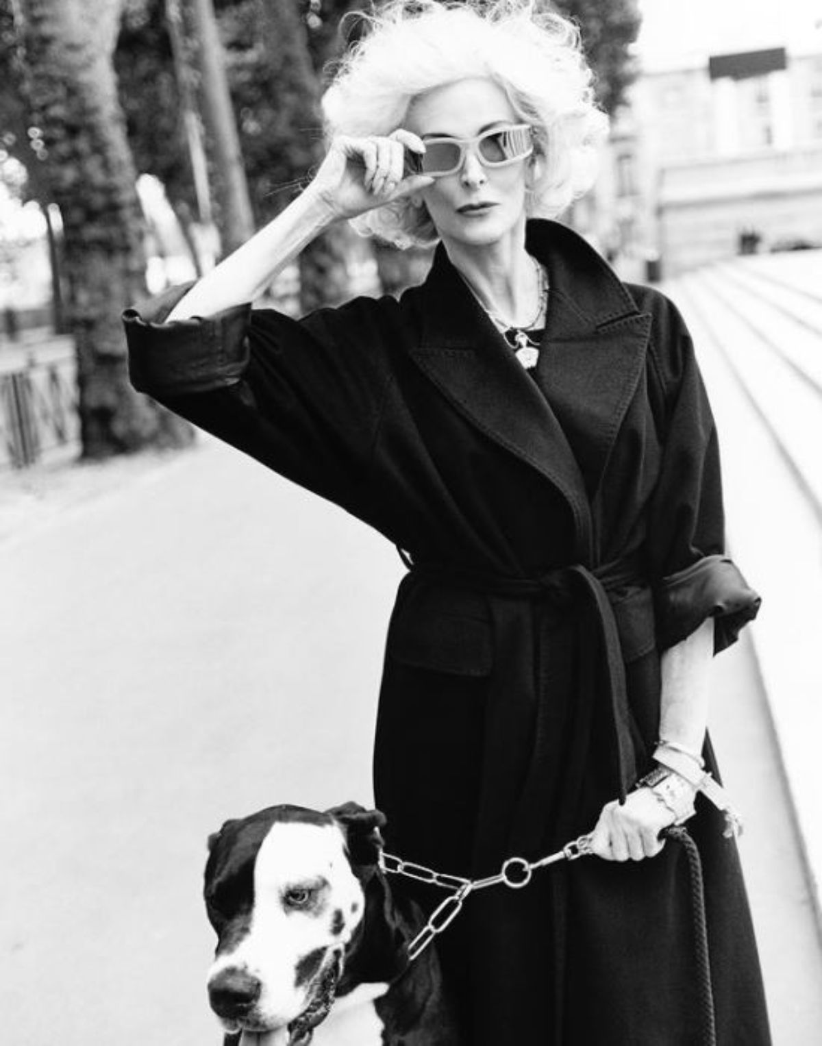 a black and white photo of Carmen Dell’Orefice in the street with her Great Dane Dog