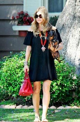 Fergie carrying her Dachshund in her arm