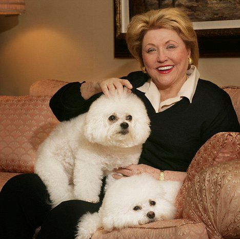 Barbara Taylor Bradford on the couch with her two Bichon Frises