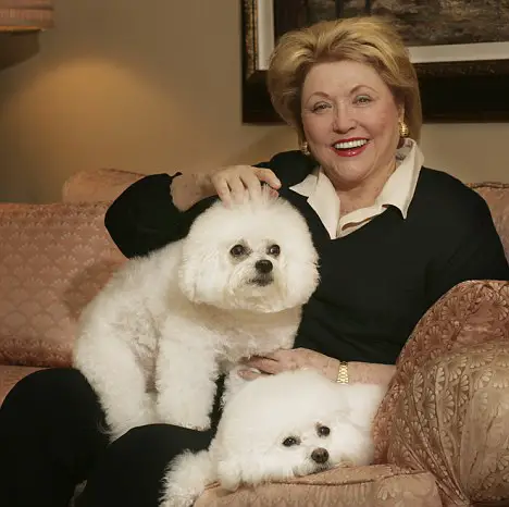 Barbara Taylor Bradford on the couch with her two Bichon Frises