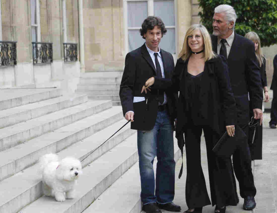 Barbra Streisand with her Bichon Frise on the stairs while holding its leash