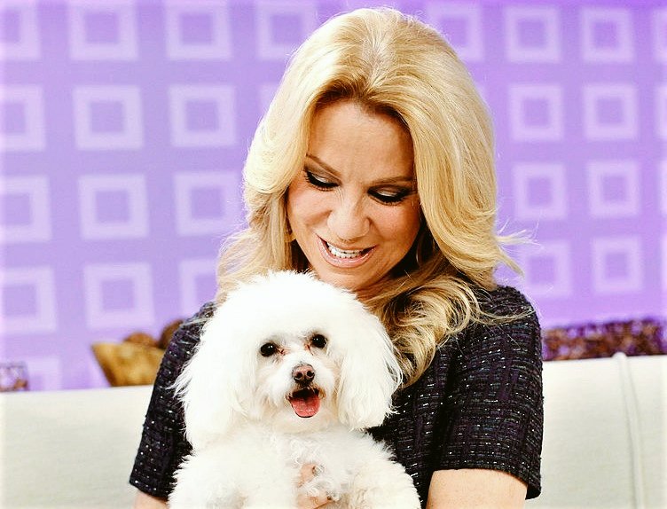 Kathie Lee sitting on a couch while looking down on her Bichon Frise in her lap